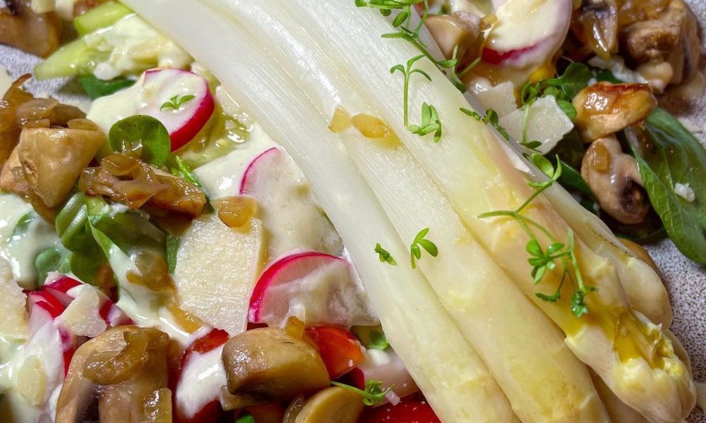 Weißer Spargel auf buntem Salatmix und einem Joghurt-Senf-Parmesan ...