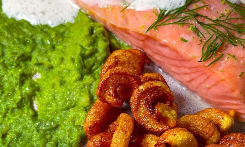 Sanft gegarter Lachs auf einem Erbsen-Stampf an Kartoffellöckchen und ...